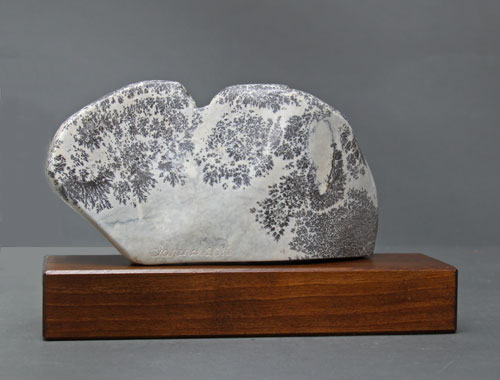 A view of the back of dendritic Soapstone Owl #20 by Clarence P. Cameron of Madison, Wisconsin